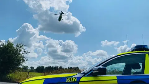 Helicopter flying over police car