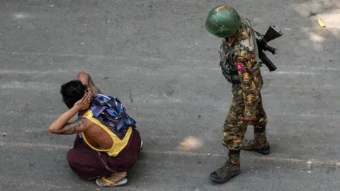 Getty Images Man sits on floor next to soldier