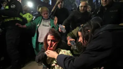 Reuters A woman is hurt during an anti-LGBTQ protest in Georgia in November