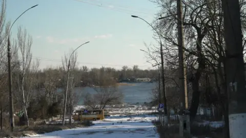 BBC The Dnipro river, seen down a street in Kherson