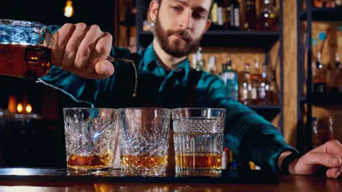 Getty Images Bartender pouring drinks