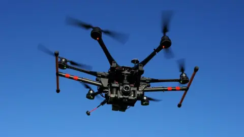 Getty Images Large drone with camera in flight