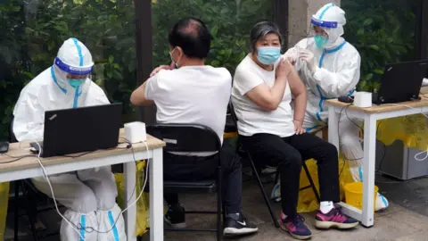 Getty Images Elderly people receive a dose of COVID-19 vaccine at a residential community on May 26, 2022 in Shanghai, China.