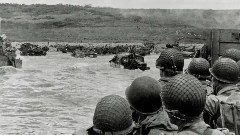 Getty Images US soldiers watch the Normandy coast from a Landing Craft Vehicle during the D-Day landings