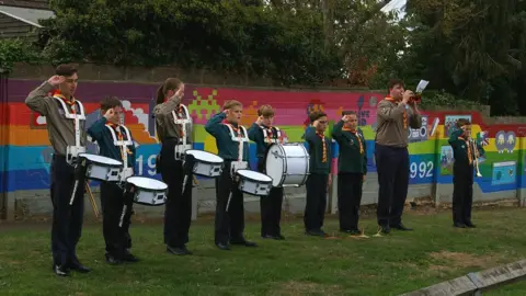 Colouring Spaces Mural Company Scout ban in front of mural at Hardingstone Recreation Ground