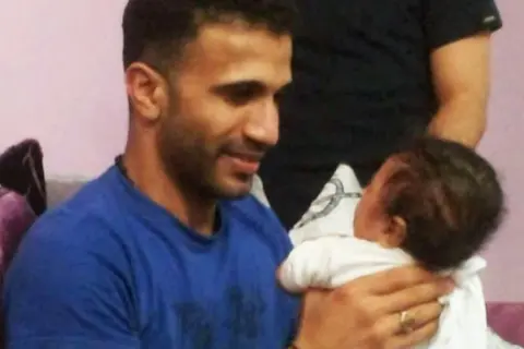 al-Khayyat Mustafa al-Khayyat, one of 81 men executed on a single day, holding his baby nephew