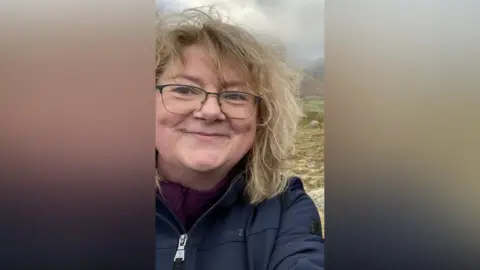 Kate Ferguson A woman takes a selfie on a hill