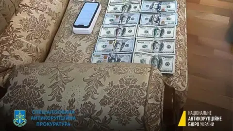 NATIONAL ANTI-CORRUPTION BUREAU OF UKRAINE/Reuters Handout image of stacks of dollar notes was posted on social media