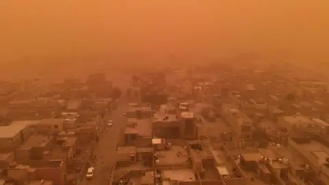 Getty Images A aerial picture taken by drone shows the southern Iraqi city of Najaf during a dust storm