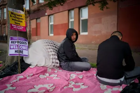 Getty Images Two Afghan refugees facing eviction went on hunger strike outside the Home Office in Glasgow in August 2018