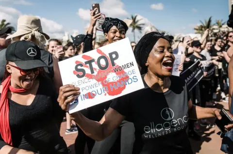 AFP Protesters hold signs and shout slogans as they take part in a march against gender based violence and in solidarity with women who have been subject to violence and in memory of those who have been killed, at the North Beach in Durban, on September 7, 2019.