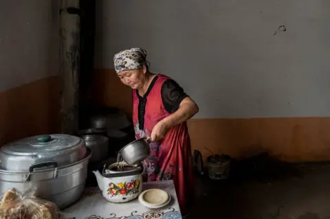 Getty Images Gulzira Auelkhan makes tea at home in her village. She was detained for 18 months