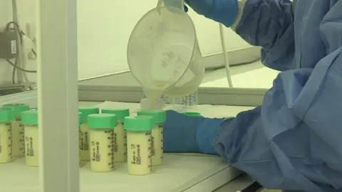 Breast milk being poured into bottles