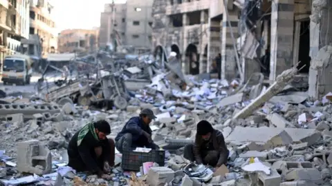 EPA Syrians pick amongst the debris around the bombed out remains of a local council building hit in an airstrike carried out by forces allied with the al-Assad regime on opposition held Douma, outskirts of Damascus, Syria, 30 December 2015