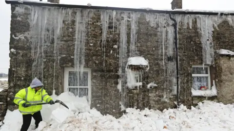 PA Mags Turnbull from Browfoot Cottage in Bowerdale in Cumbria digs herself out after being snowed in for three days