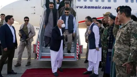 Reuters Afghanistan President Ashraf Ghani (centre) meets local leaders and commanders at Mazar-i-Sharif airport, Afghanistan. Photo: 11 August 2021