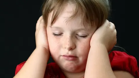 Getty Images Child with hands over ears