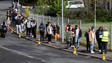 Reuters People queue outside a mobile Covid vaccination centre in Bolton