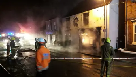 Humberside Fire & Rescue Service Firefighters in front of a burning building