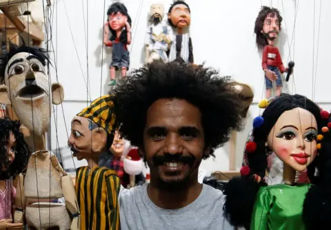Reuters A puppeteer holds his dolls.