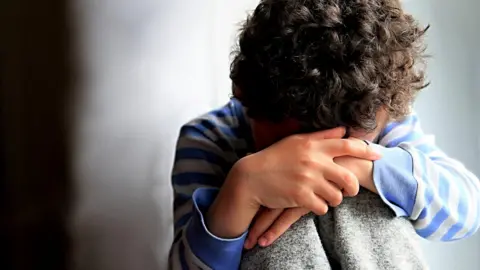 Getty Images Child hiding their face