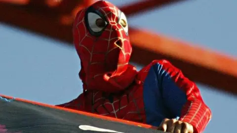 Chick dressed as Spider-man on a crane near Tower Bridge