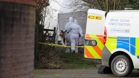 Getty Images Police scientific officers work at a crime scene in Alness Drive