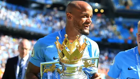 Vincent Kompany holds the Premier League trophy