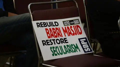 Getty Images A placard is seen on a chair during a protest by Indian activists to mark the 24th anniversary of the destruction of the Babri Mosque in New Delhi on December 6,2016.