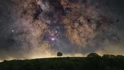 Carl Gough/SDNPA A night sky above Cissbury Ring with flashes of purple and blue among the stars