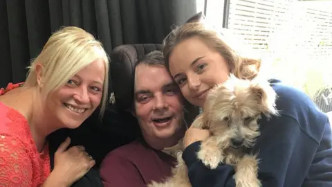 Family handout Simon Dobbin with his wife Nicole and daughter Emily