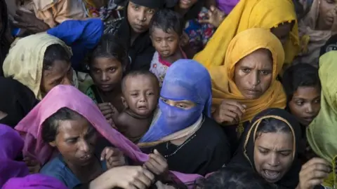 Getty Images Rohingya reach out for clothing and food on 15 September 2017 in Tankhali, Bangladesh