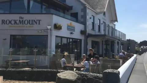 People sitting outside a pub having a drink.