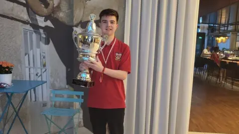 Jenson Walker Jenson Walker holds up a trophy