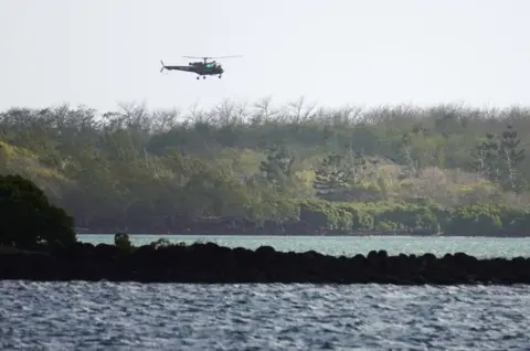 Reuters Search and rescue helicopter flies over the site of the collision off Mauritius on 31 August 2020