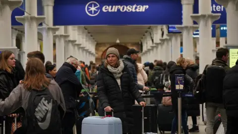 PA Media Passengers at the entrance to Eurostar in St Pancras International station