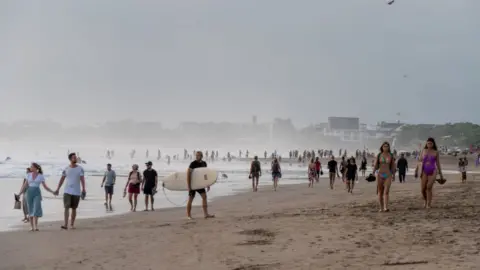 Getty Images BALI, INDONESIA - 2022/09/17: Large crowds of tourists and expats are seen at Seminyak Beach. Tourism in Indonesia is picking up after the covid 19 pandemic.