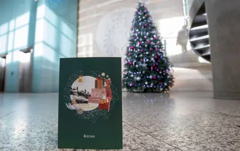 GCHQ / PA Media GCHQ Christmas card in front of Christmas tree at GCHQ