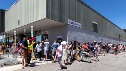EPA People queue outside a supermarket in Perth, Australia, on 31 January 2021