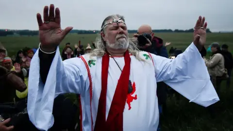 Reuters Arch-Druid Arthur Pendragon speaks in front of Stonehenge ancient stone circle, during the celebrations of the Summer Solstice, despite official events being cancelled amid the spread of the coronavirus disease