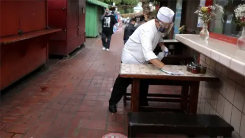 Reuters Baltazar Ayala, 54, cleans a dining table at La Noche Buena restaurant in Los Angeles, which is on the cusp of reopening parts of its economy if the county reaches 2 million coronavirus disease (COVID-19) vaccinations administered in disadvantaged areas, in Los Angeles, California, U.S., March 11, 2021.