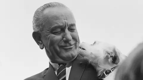 Getty Images US President Lyndon B Johnson introduces his pet dog Yuki at a Country Fair on the South Lawn of the White House, Washington, DC, September 1967.