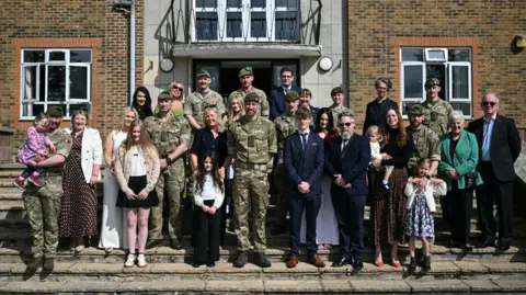 JUSTIN TALLIS/Pool via REUTERS Britain's Prince William, Prince of Wales as Colonel-in-Chief of the Regiment, poses with soldiers of the 1st Battalion Mercian Regiment and family members following their six-month deployment to Estonia, in Bulford, Britain, March 26, 2026. JUSTIN TALLIS/Pool via REUTERS