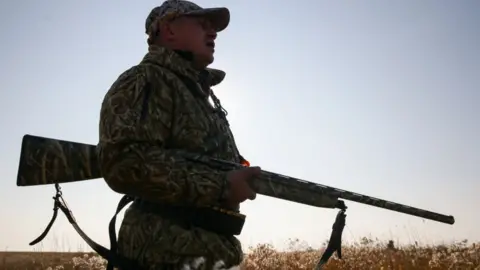 Getty Images A Russian hunter with shotgun (file pic)