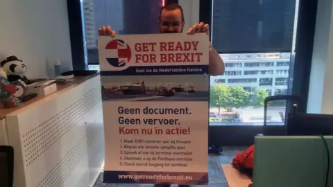 A Dutch worker holding a prepare for Brexit sign