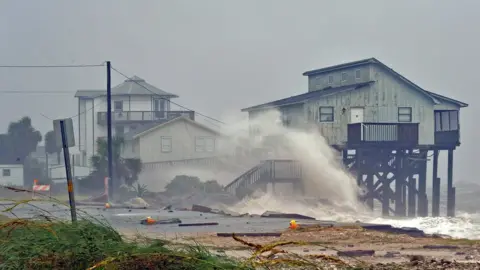 Reuters Waves crash into stilt houses along the shore at Alligator Point in Franklin County, Florida