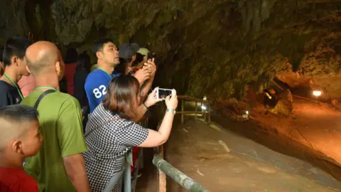 EPA/CHIANG RAI PROVINCIAL PUBLIC RELATIONS OFFICE People take photographs at the entrance of the Tham Luang cave in Mae Sai district, Chiang Rai province, Thailand, on 01 November 2019.