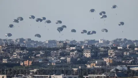 Reuters Humanitarian aid falls through the sky towards the Gaza Strip after being dropped from an aircraft