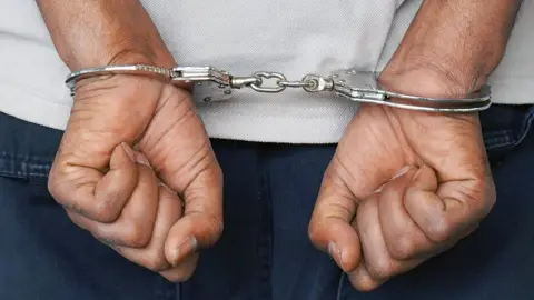 iStock Arrested man handcuffed hands at the back