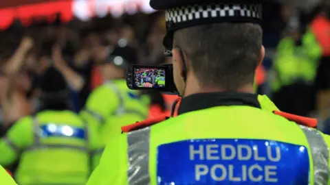 Getty Images South Wales Police officer filming fans